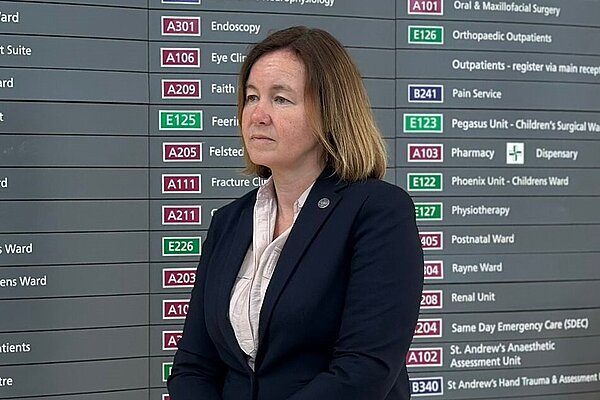 Marie standing by a sign at Broomfield Hospital